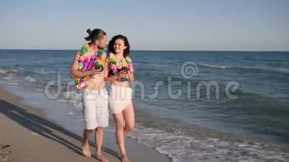 男人手牵着女孩赤脚走在沙滩上情侣相爱异国情调的假期背景海滩全景视频的预览图