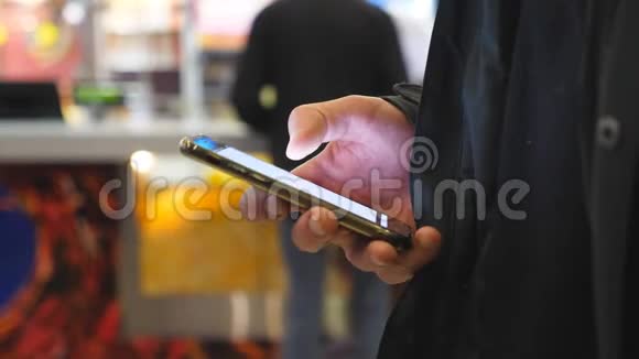 在购物中心使用智能手机的人手臂男性手在智能手机上浏览信息和滚动图片视频的预览图