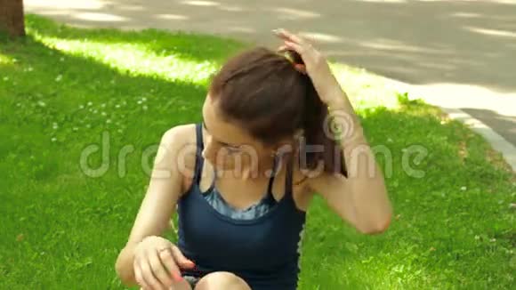 漂亮的健身女孩躺在草地上摇着报纸视频的预览图