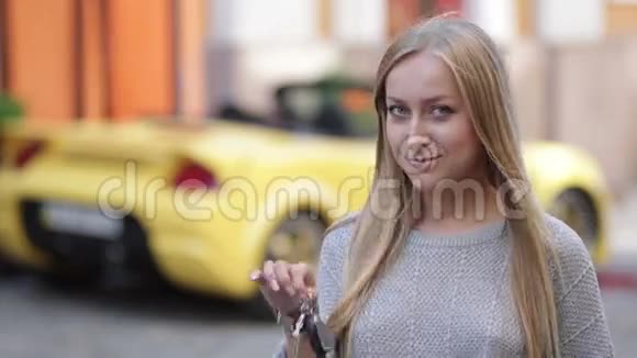 年轻微笑的女人拿着新车的钥匙视频的预览图