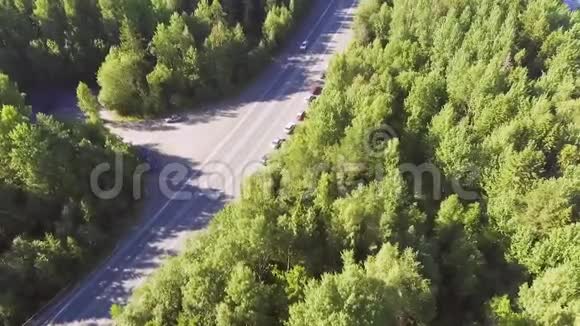 夏季森林公路上汽车交通的鸟瞰图视频的预览图