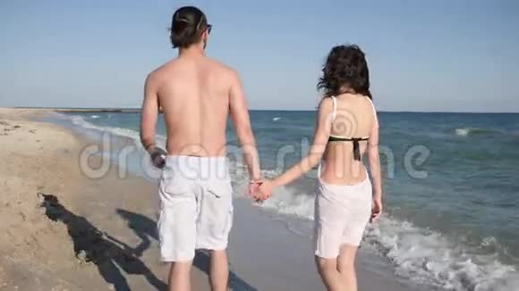 情侣们赤脚在沙滩上散步夏天情侣们在沙滩上浪漫地散步情侣们相爱异国情调视频的预览图