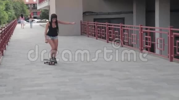 女孩或女人在一栋大楼前的滑板上溜冰穿着短牛仔短裤视频的预览图