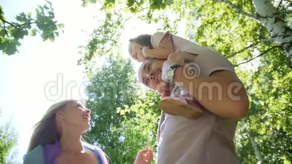 父亲母亲和女儿在阳光明媚的日子在公园里玩得很开心动作很慢视频的预览图