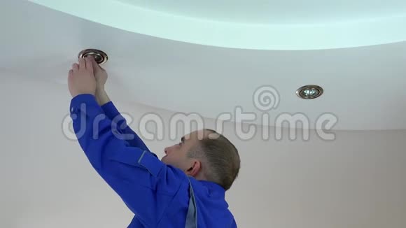 年轻电工将卤素点灯安装或更换为天花板视频的预览图