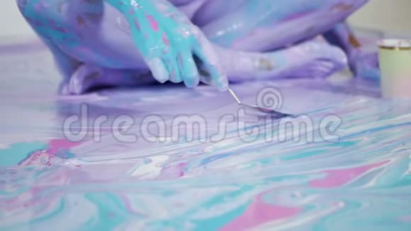 女性瑜伽点缀在画布上抽象图案和颜料视频的预览图