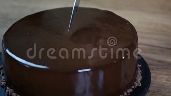 上釉巧克力慕斯蛋糕特写用刀切一块巧克力蛋糕视频的预览图