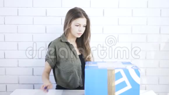 年轻女孩打开盒子用固定的刀视频的预览图