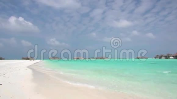 迷人的稳定拍摄平静的绿松石海洋天堂水波在热带海滩海岸海岸线与棕榈树视频的预览图