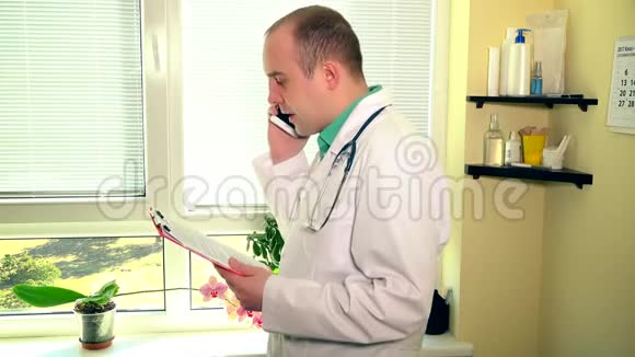 一名医生病人夹案打智能电话以防窗灯视频的预览图