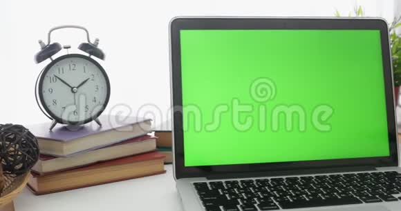 4K一台笔记本电脑在工作办公室桌子上设置一个绿色的关键屏幕多莉向左向右移动视频的预览图