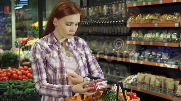 女人看着她在超市买的东西视频的预览图