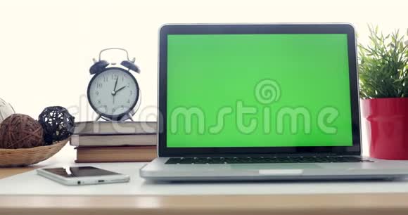 4K一台笔记本电脑在工作办公室桌子上设置一个绿色的关键屏幕多莉向左向右移动视频的预览图