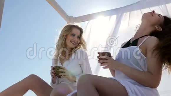 在海滩上的女朋友聚会在风白色窗帘中发展视频的预览图