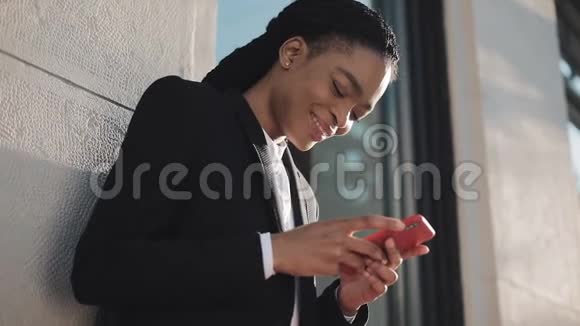 时尚的非洲女商人使用智能手机站在商业中心附近的街道上黑色时尚可怕的家伙非洲裔视频的预览图