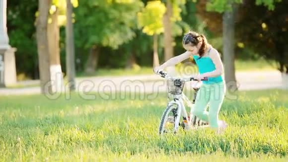 夏天温暖的一天快乐的孩子在城市公园骑自行车视频的预览图