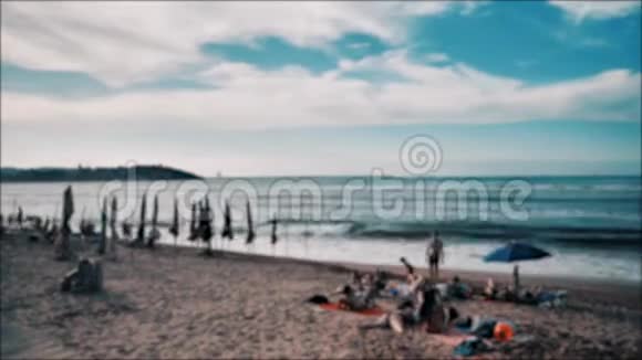 大西洋沿岸坎塔布里亚海许多日光浴的人五颜六色的雨伞视频的预览图