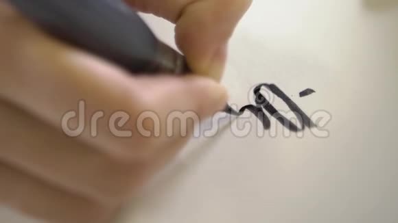 毛笔在纸上画书法字母的特写视频的预览图