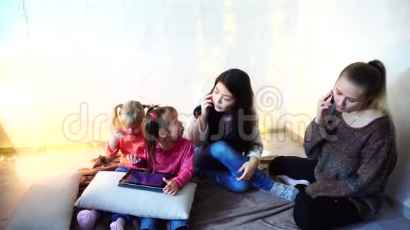 年长的妇女和女婴四人交流忙于自己的事情坐在墙上的背景上和视频的预览图