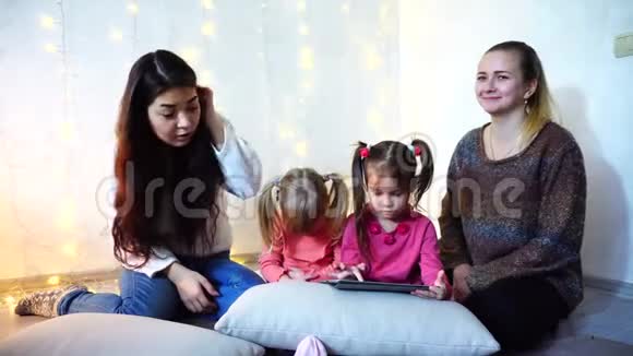 年长的妇女和女婴四人交流忙于自己的事情坐在墙上的背景上和视频的预览图