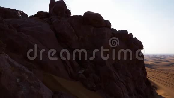 阳光充足的沙漠中的石山和沙丘落基山沙漠景观视频的预览图