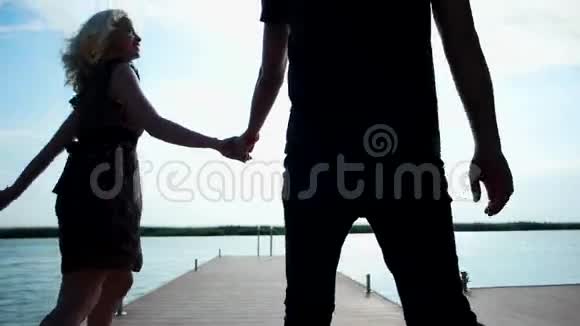 幸福的一对走在码头上牵手的情侣阳光下温柔浪漫的一对恋人视频的预览图