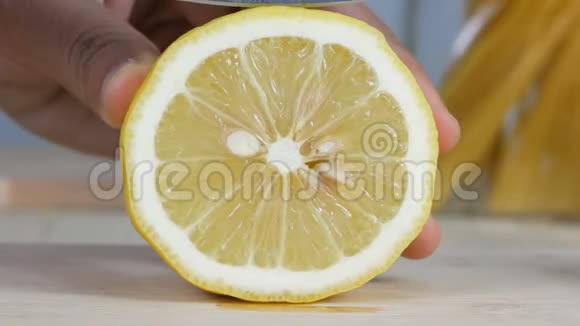 用厨房的刀切下新鲜柠檬的女人的手视频的预览图