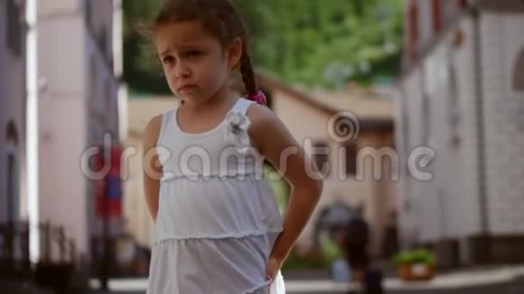 一个金发可爱的小卷发女孩很伤心同时在舞蹈中旋转在街上旋转视频的预览图