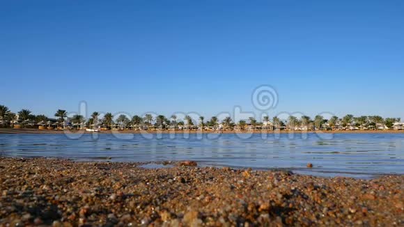 沙滩上有小石子美丽的蓝天小浪慢慢滚到岸边视频的预览图