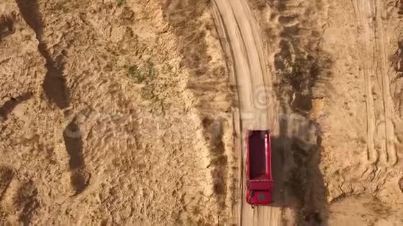 卡车在农村公路上行驶的俯视图场景夏天自卸卡车在干黄的采石场道路上行驶重型机械视频的预览图