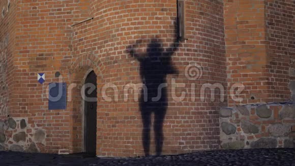 在阴影中一个积极跳舞的女孩在石墙上的轮廓视频的预览图
