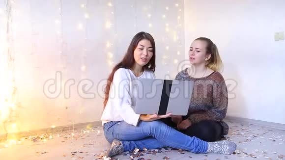两个漂亮的女孩坐在客厅的地板上在网上商店挑选商品视频的预览图