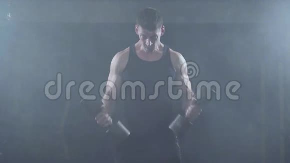 强壮的年轻肌肉男性健美运动员在健身房锻炼二头肌和哑铃视频的预览图