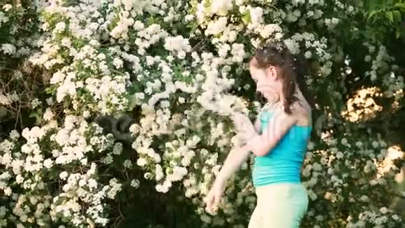 可爱的小女孩在夏天闻花在公园里玩视频的预览图