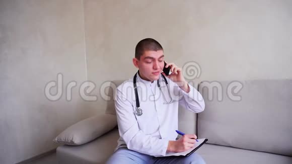 负责的男医生的肖像他在细胞上交流与病人协商坐在办公室的沙发上视频的预览图