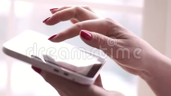 女人在平板电脑上键入文本那个女人拿着平板电脑坐在窗口女人在搜索框里打字视频的预览图