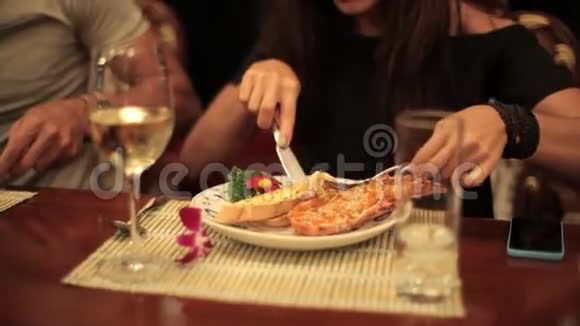 用叉子和刀子在盘子里吃龙虾的女人的特写视频的预览图
