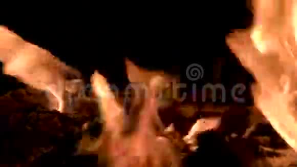 在晚上燃烧火焰有燃烧木材的壁炉在黑色背景上开火视频的预览图