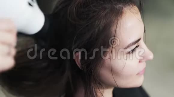 美发店里用吹风机将女性湿发擦干视频的预览图