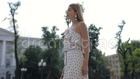 美丽优雅的女人穿着礼服漫步在夏城视频的预览图