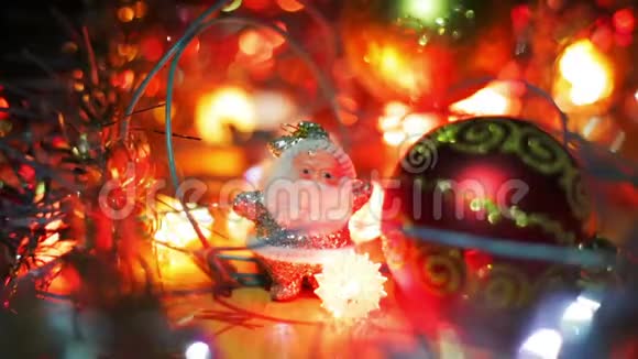 一个银白色的圣诞老人的小身影站在一个红色的圣诞节旁边把包布挂在桌子上圣诞花环闪烁视频的预览图
