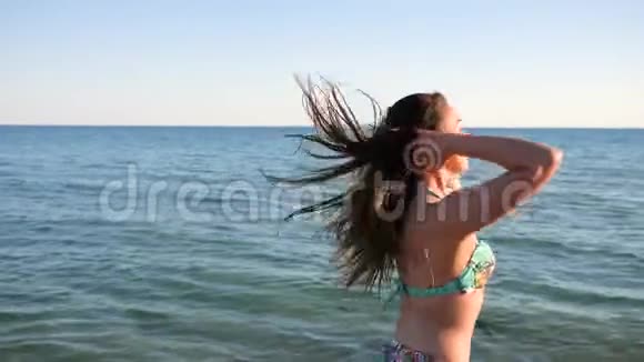 肖像奔跑的女孩美丽的年轻女子在海滩上与大海赛跑穿着泳装的女性身材视频的预览图