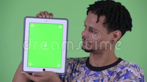 一位年轻英俊的年轻非洲男子展示数码平板电脑的脸视频的预览图