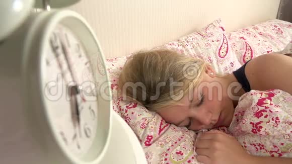 少女在床上醒来关掉闹钟视频的预览图