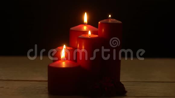 五支红烛照亮了白木桌上的火焰浪漫的主题视频的预览图