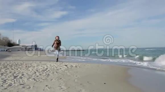 美丽的女人在阳光明媚的海滩上奔跑视频的预览图
