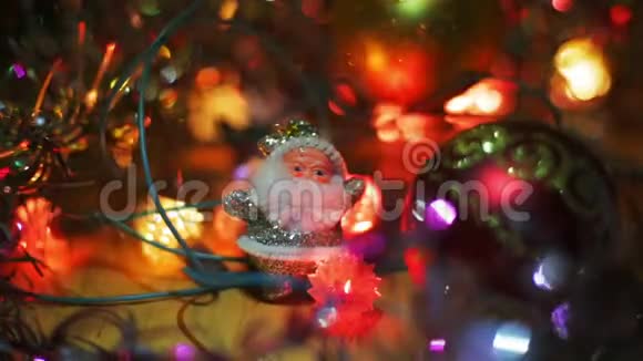 一个银白色的圣诞老人的小身影站在一个红色的圣诞节旁边把包布挂在桌子上圣诞花环闪烁视频的预览图