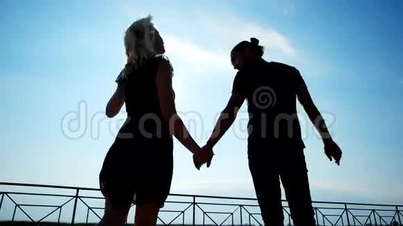 一对甜蜜的情侣在阳光下牵手风吹着头发一对情侣在码头上享受阳光视频的预览图
