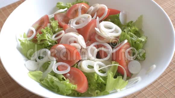 蔬菜生菜洋葱和番茄沙拉混合在一个白色的碗里视频的预览图
