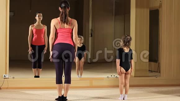 教一个体操小女孩这个女孩正在学习鞠躬老师教编舞视频的预览图